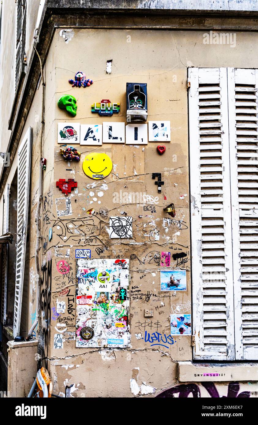 Muro con arte di strada in una strada del Butte di Montmartre, 18° arrondissement di Parigi, Francia. Foto Stock