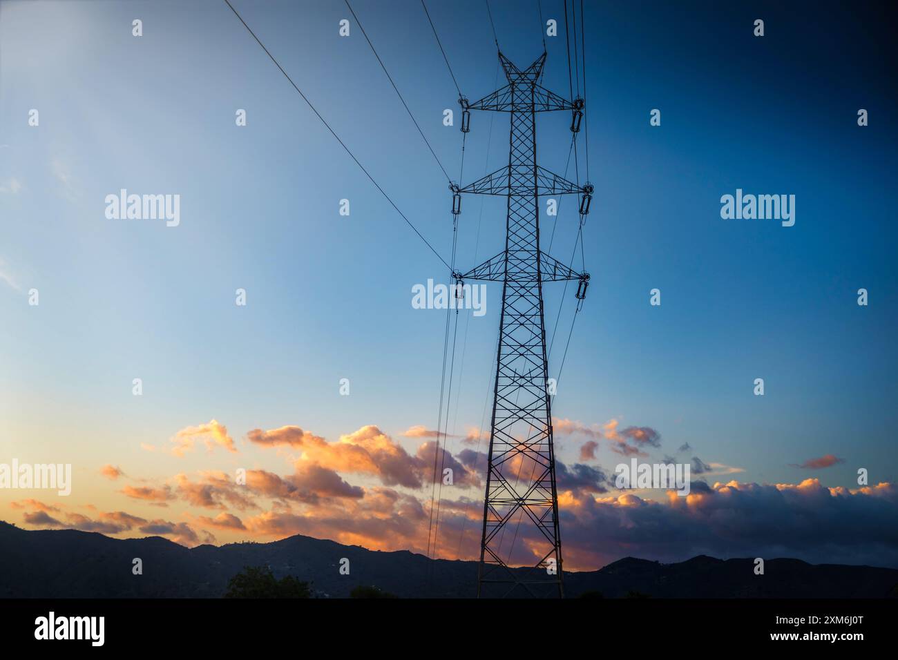 pilone elettrico ad alta tensione noto anche come torre di alimentazione o torre di trasmissione elettrica sagomata contro un cielo che mostra una splendida tavolozza di Foto Stock