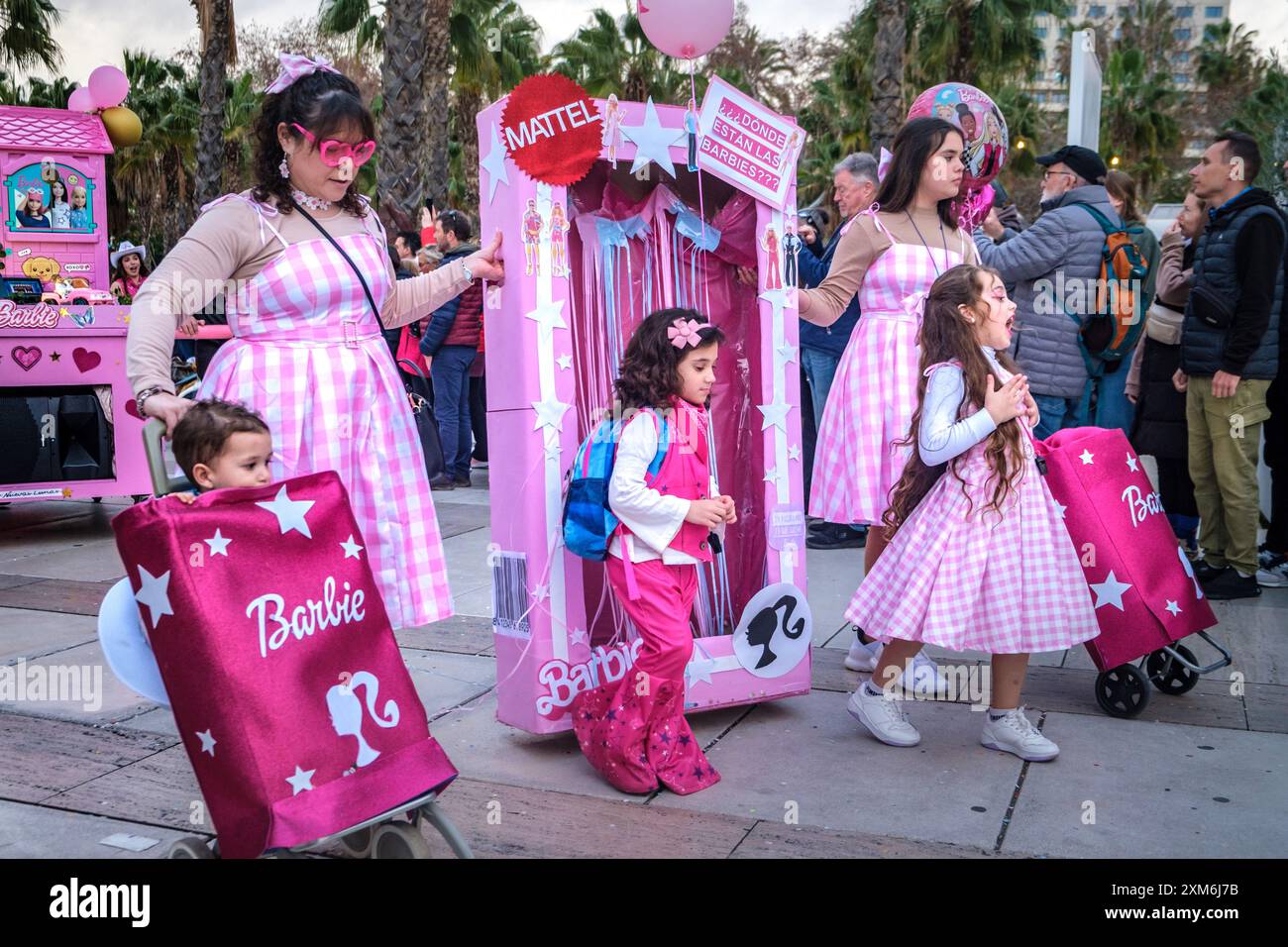 Ensemble a tema Barbie, adulti e bambini con abiti rosa e abbigliamento con logo in occasione di eventi all'aperto, sfilate o feste di marca. Foto Stock