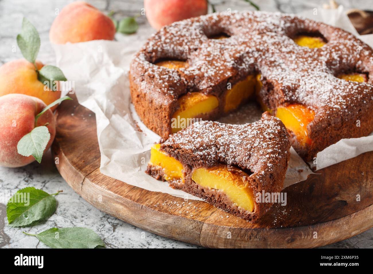 Delizioso brownie di pesca al cacao o torta di spugne di pesca al cioccolato primo piano su un tavolo di legno. Orizzontale Foto Stock