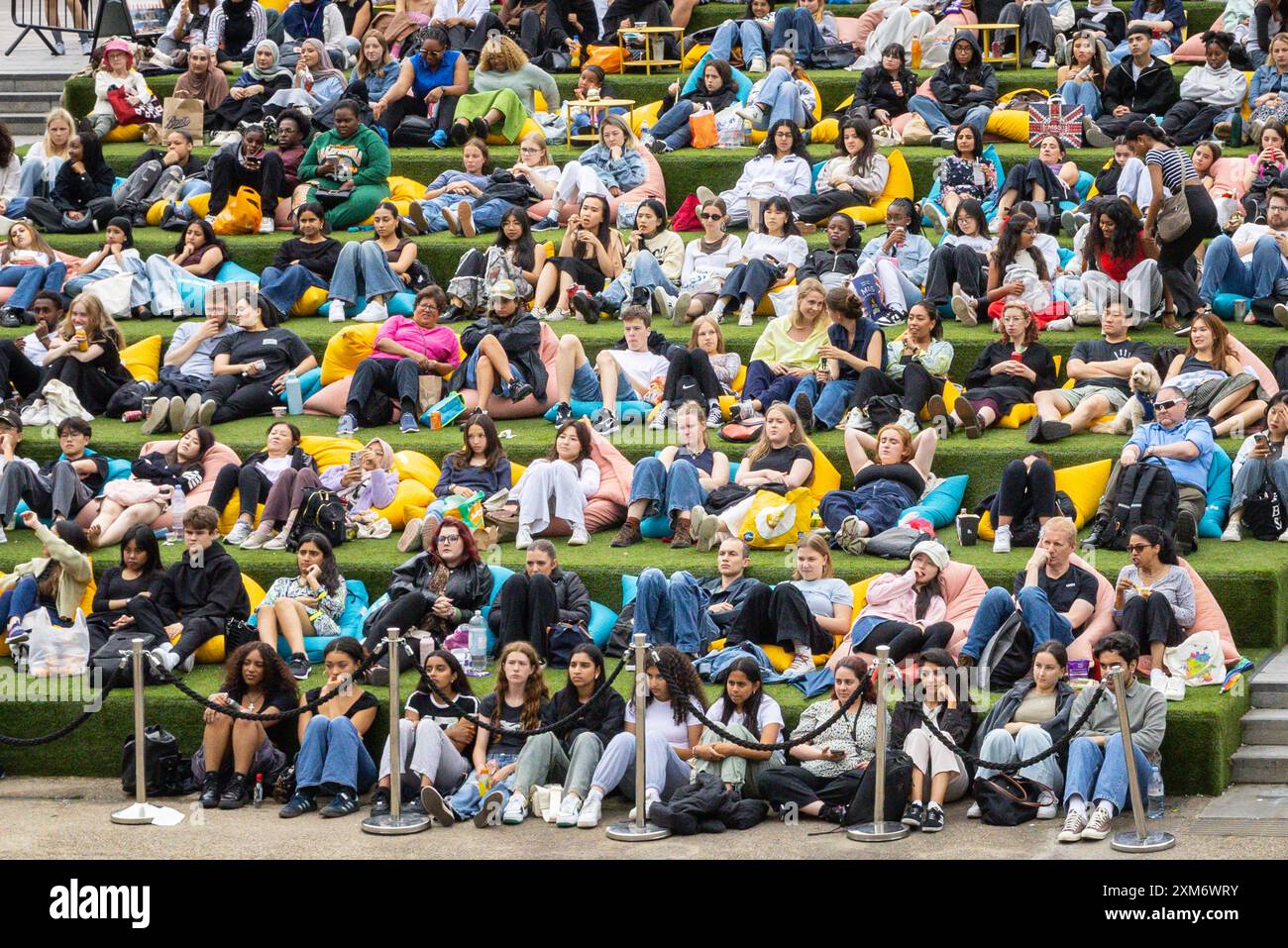 Londra, Regno Unito. 25 luglio 2024. Le persone guardano il cinema all'aperto gratuito all'Everyman on the Canal, un grande schermo installato a Granary Square Steps, King's Cross, nonostante il clima umido e mutevole di oggi, e sembrano godersi la loro estate con l'intrattenimento della città. Everyman on the Canal proietta 4 film al giorno tra il 1° luglio e il 18 agosto. Crediti: Imageplotter/Alamy Live News Foto Stock