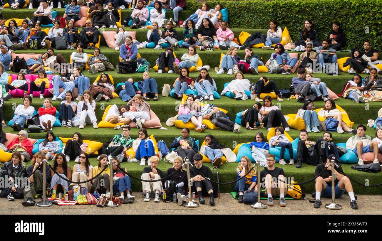 Londra, Regno Unito. 25 luglio 2024. Le persone guardano il cinema all'aperto gratuito all'Everyman on the Canal, un grande schermo installato a Granary Square Steps, King's Cross, nonostante il clima umido e mutevole di oggi, e sembrano godersi la loro estate con l'intrattenimento della città. Everyman on the Canal proietta 4 film al giorno tra il 1° luglio e il 18 agosto. Crediti: Imageplotter/Alamy Live News Foto Stock