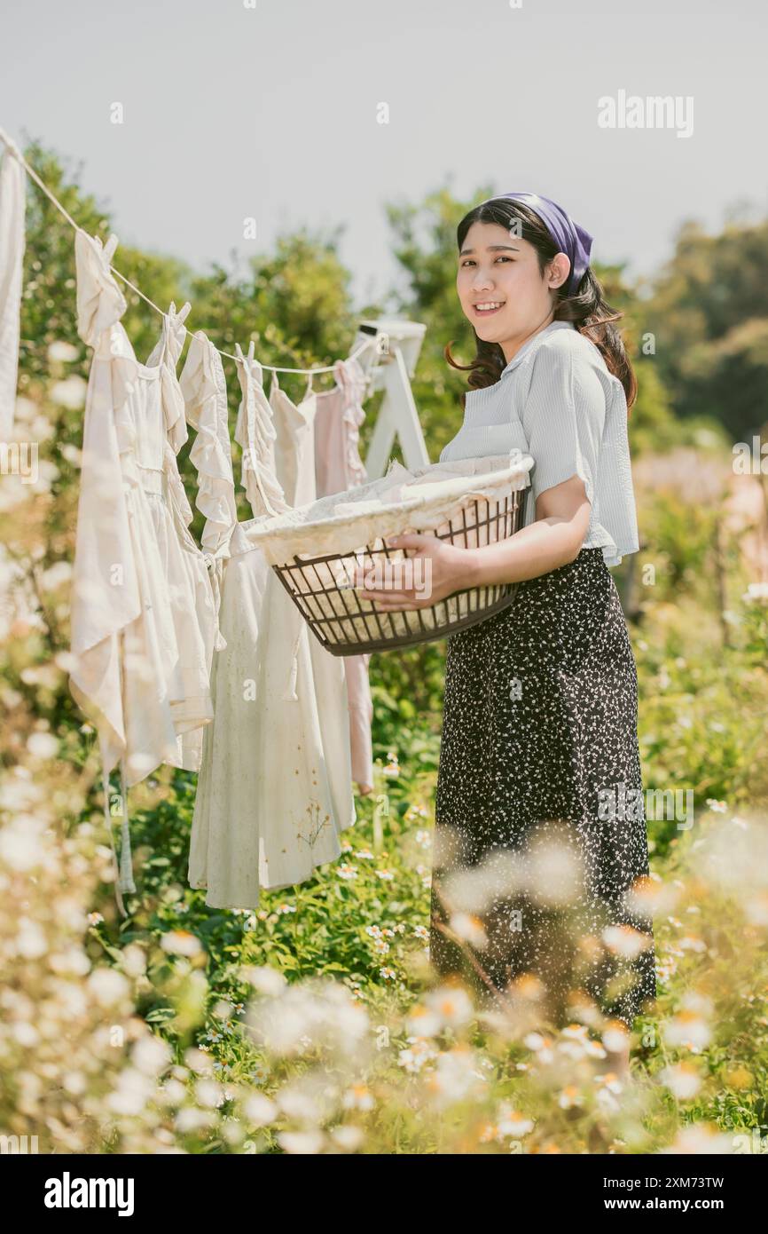 Contadino contadino donne popolari cameriera casalinga che asciuga i vestiti all'aperto vintage stile retrò gente di campagna. Foto Stock