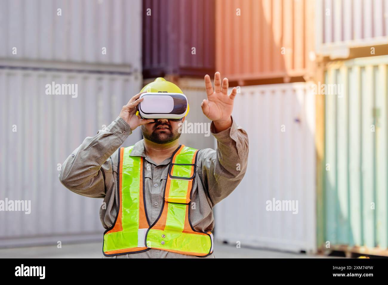 I lavoratori che utilizzano dispositivi con cuffie e auricolari VR Vision Pro Technology lavorano presso Container Yard Construction Site innovazione nel settore della logistica Foto Stock