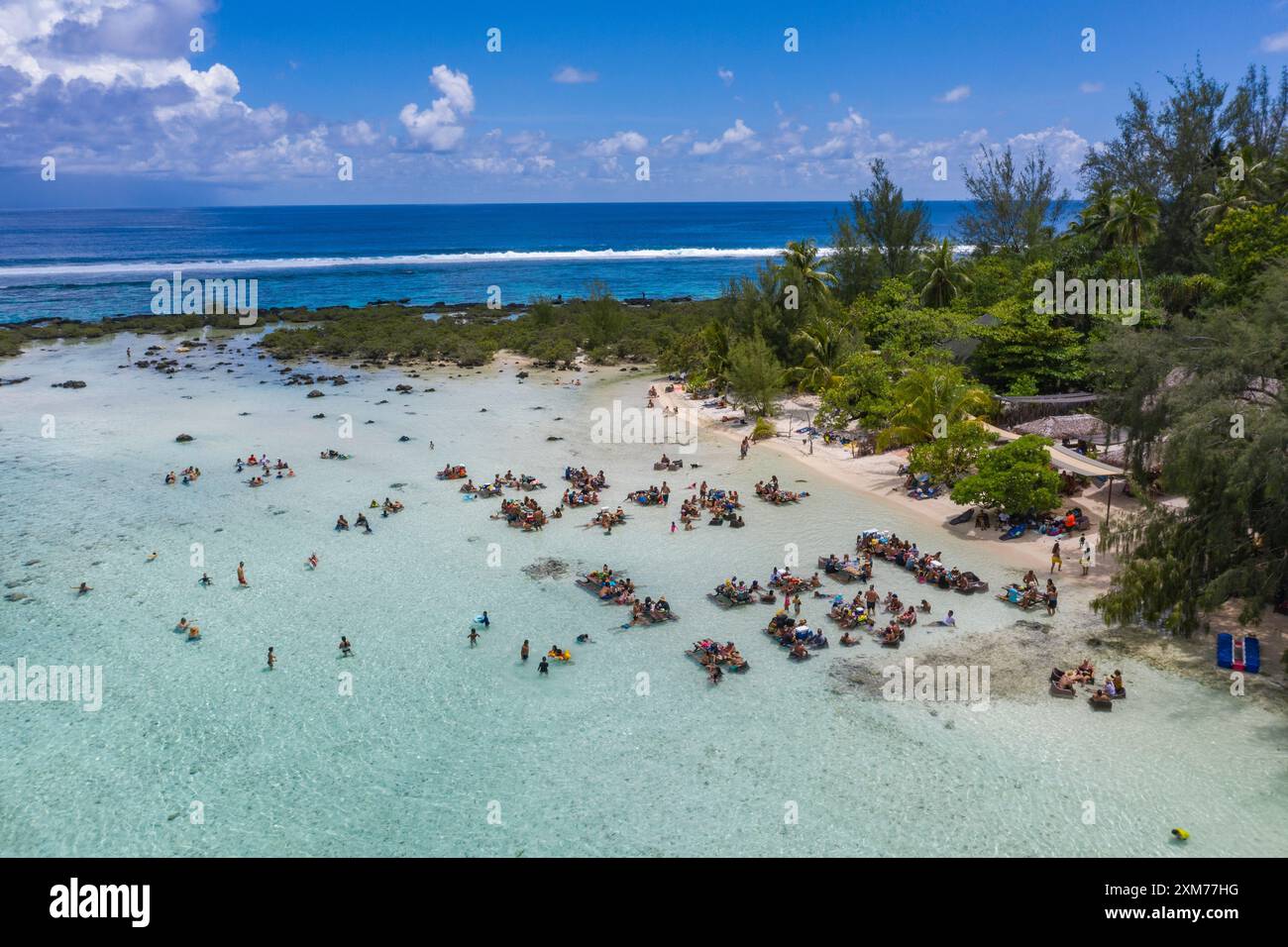 Vista aerea di persone che si rilassano e ascoltano musica dal vivo mentre si siedono ai tavoli da picnic nella laguna, a Moorea, alle isole Windward, alla Polinesia francese, S. Foto Stock