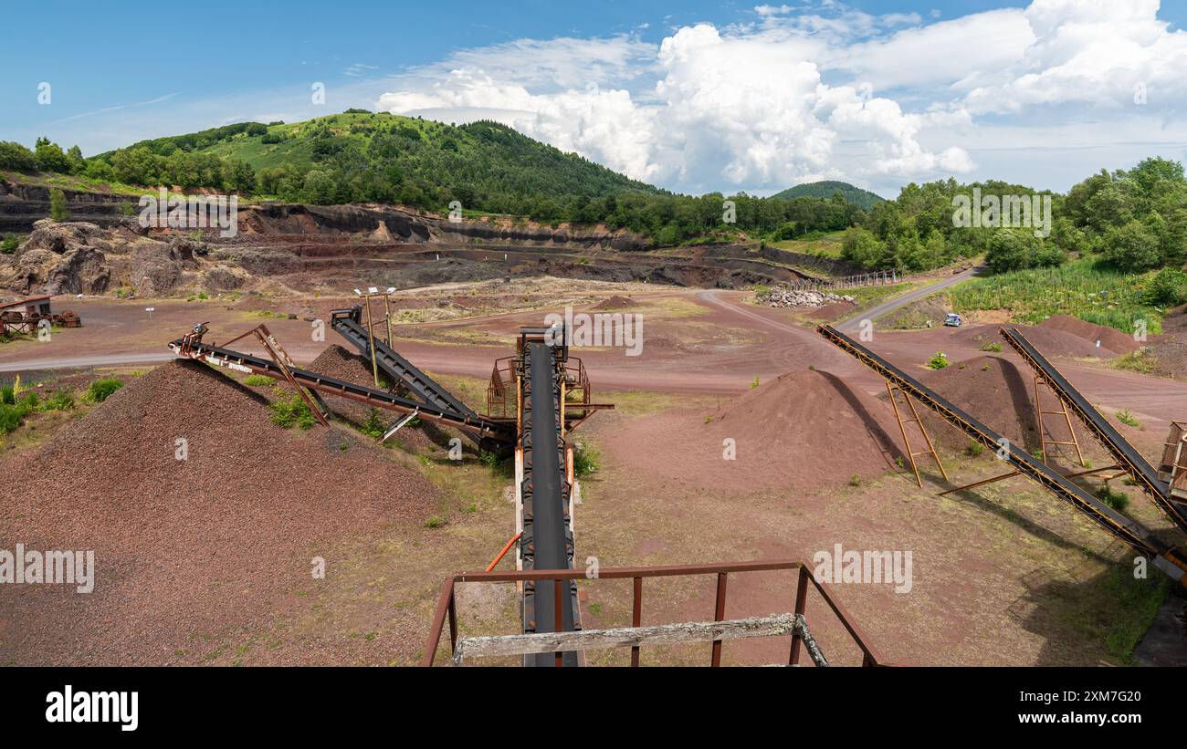 Interno del vulcano francese Lemptégy con macchine di estrusione in primo piano, utilizzate come cava. Foto Stock