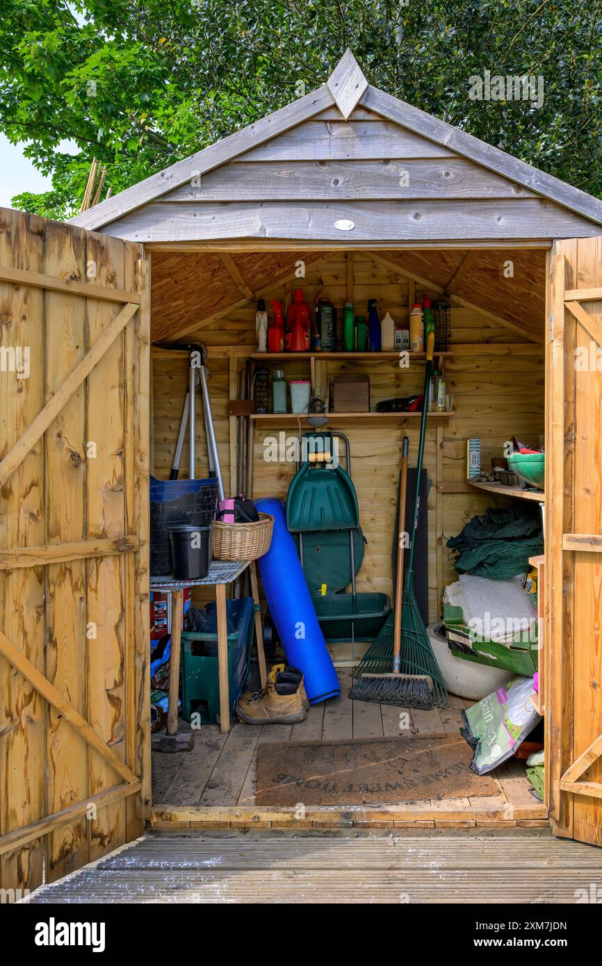 Capannone in giardino che mostra una serie di pezzi e pezzi da giardinaggio Foto Stock