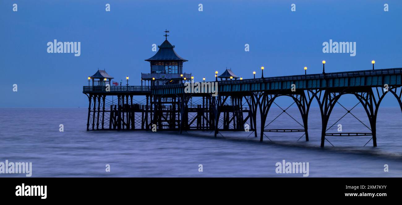 Molo di Clevedon, Regno Unito, al tramonto nell'ora blu con le luci del molo accese. Panoramica Foto Stock