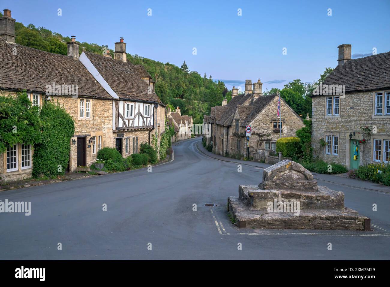 Castle Combe Village nel Wiltshire in estate, tarda sera al crepuscolo. Foto Stock