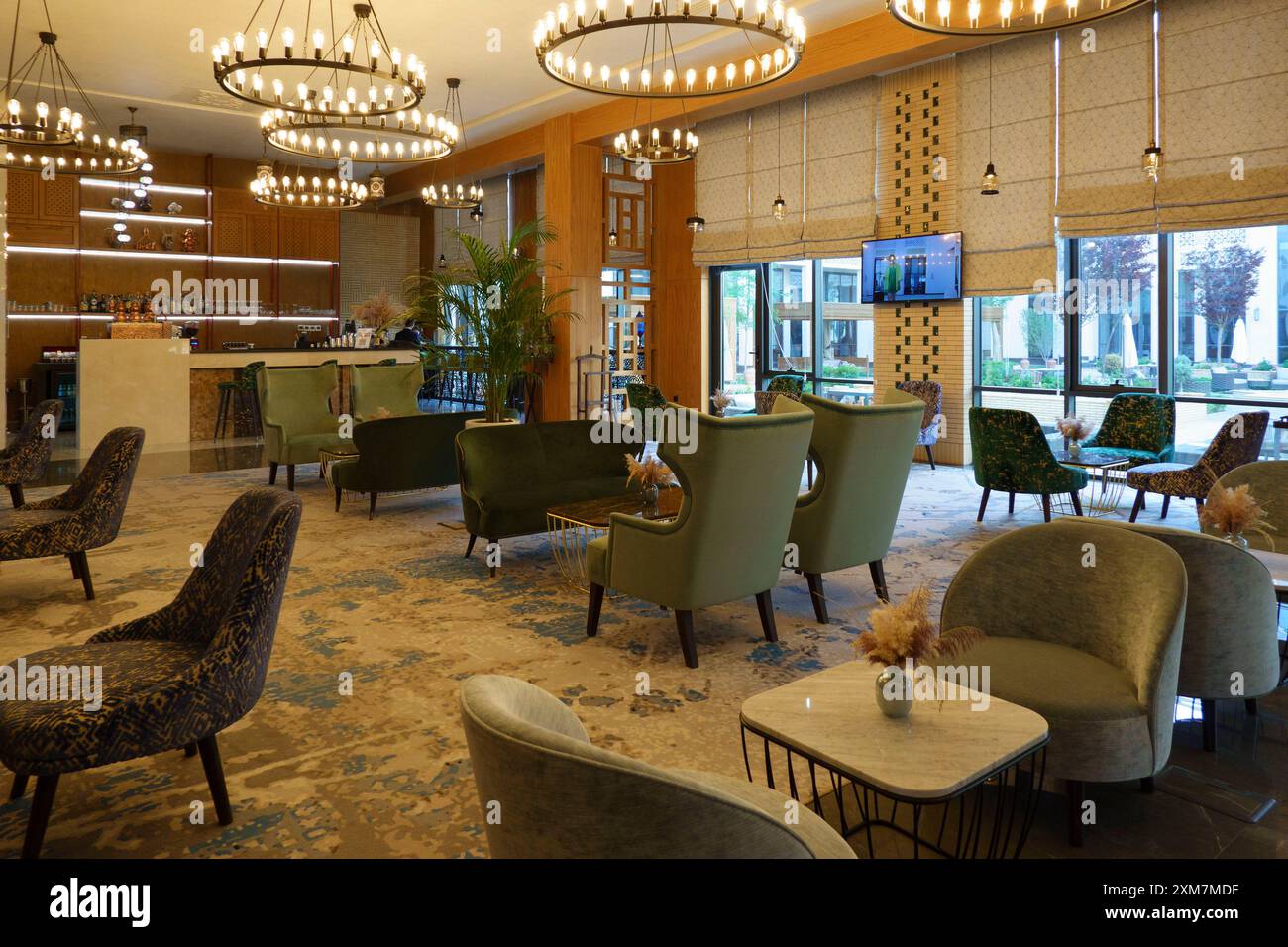 Lounge dell'hotel Farovon con lussuose poltrone, illuminazione decorativa e una moderna area bar a Khiva, Uzbekistan Foto Stock