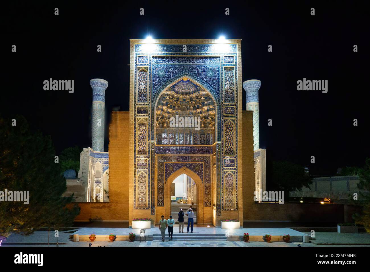Vista notturna dell'ingresso illuminato al Mausoleo di Gur-e-Amir Timur a Samarcanda, Uzbekistan, con intricati motivi a mosaico e visite a piedi Foto Stock