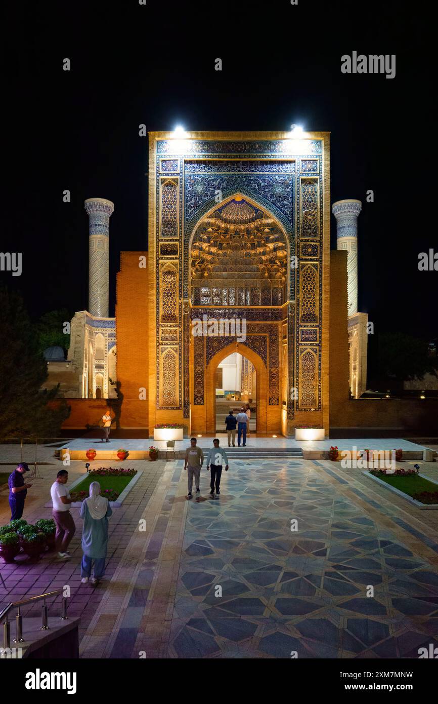 Vista notturna dell'ingresso illuminato al Mausoleo di Gur-e-Amir Timur a Samarcanda, Uzbekistan, con intricati motivi a mosaico e visite a piedi Foto Stock