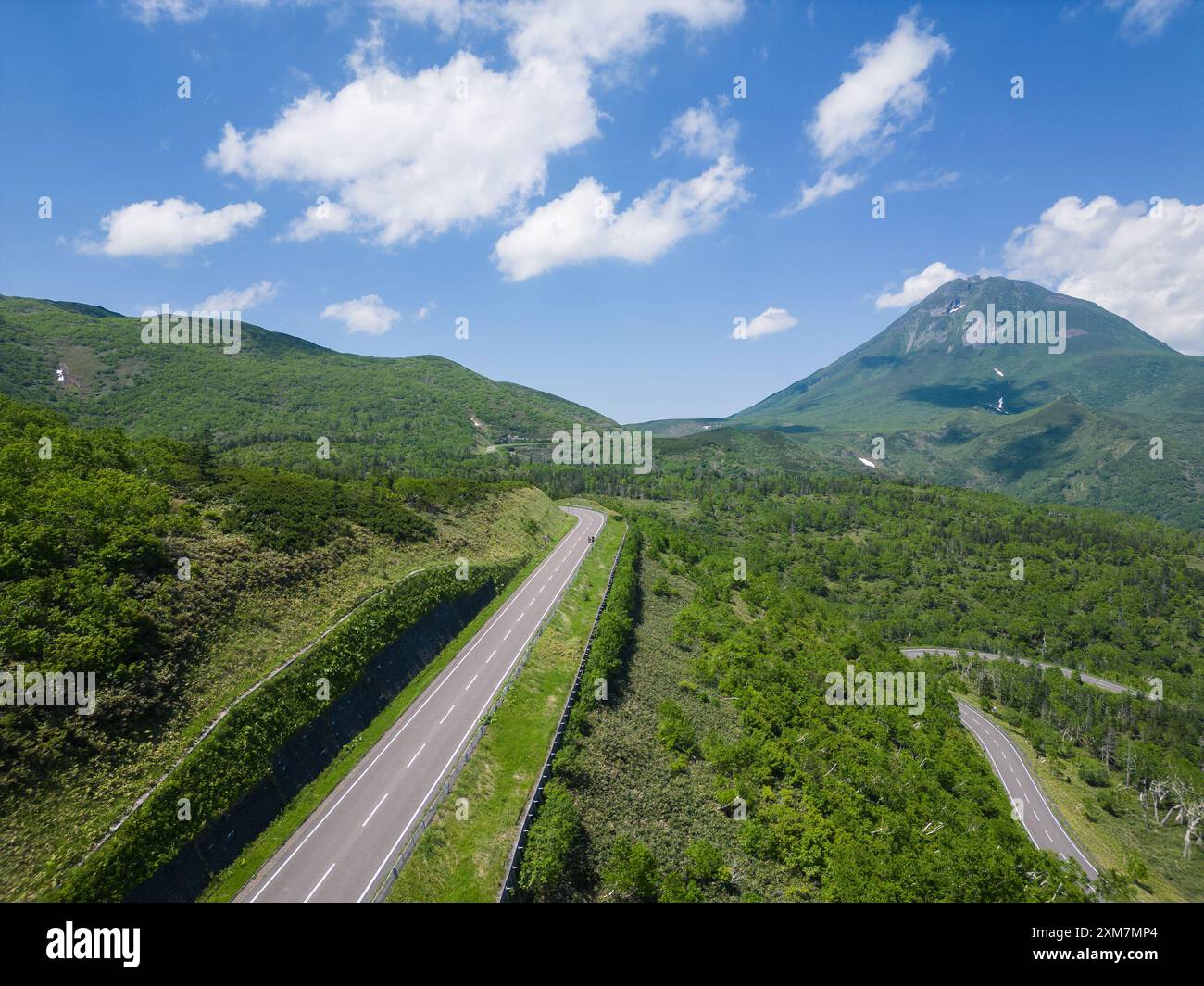 Rausu, Hokkaido: Veduta aerea della strada del passo di Shiretoko con il vulcano del Monte Rausu nella penisola di Shiretoko tra Utoro e la città di Rausu su una soleggiata S Foto Stock