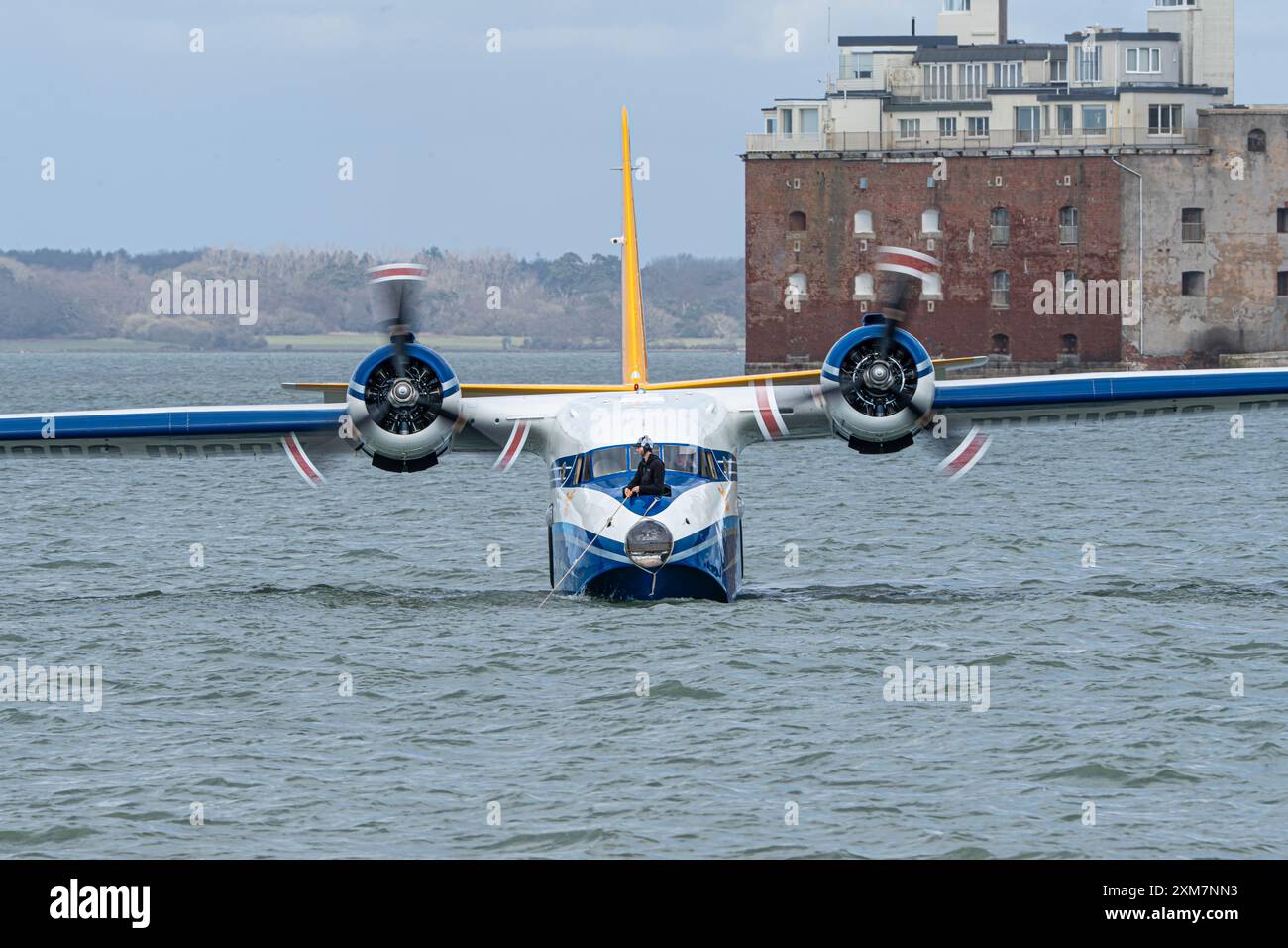 Idrovolante Grumman HU-16 Albatross decolla dal mare a Colwell Bay, isola di Wight, membro dell'equipaggio che solleva l'ancora mentre motori e eliche girano Foto Stock