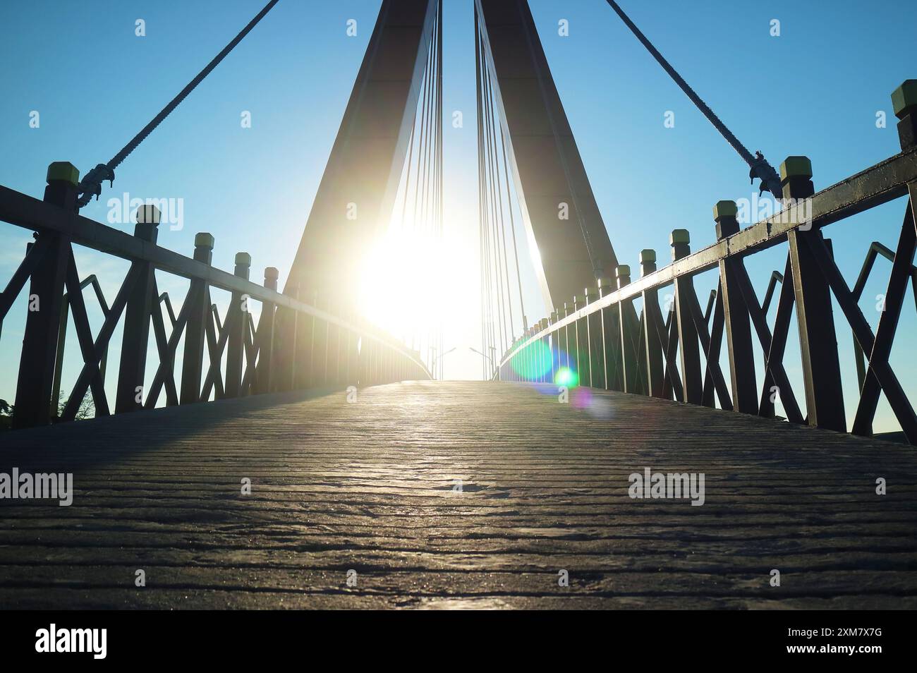 Incredibile sole luminoso che sorge sul ponte sospeso Foto Stock