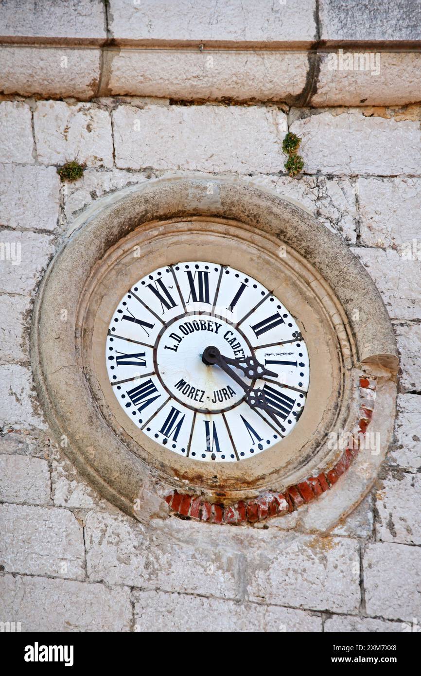 Gourdon, Francia - 20 gennaio 2012: Orologio a quadrante bianco con numeri romani L D Odobey Cadet Morez Jura presso Stone Building in Village. Foto Stock Gourdon, Francia - 20 gennaio 2012: Orologio a quadrante bianco con numeri romani L D Odobey Cadet Morez Jura presso Stone Building in Village. Foto Stock