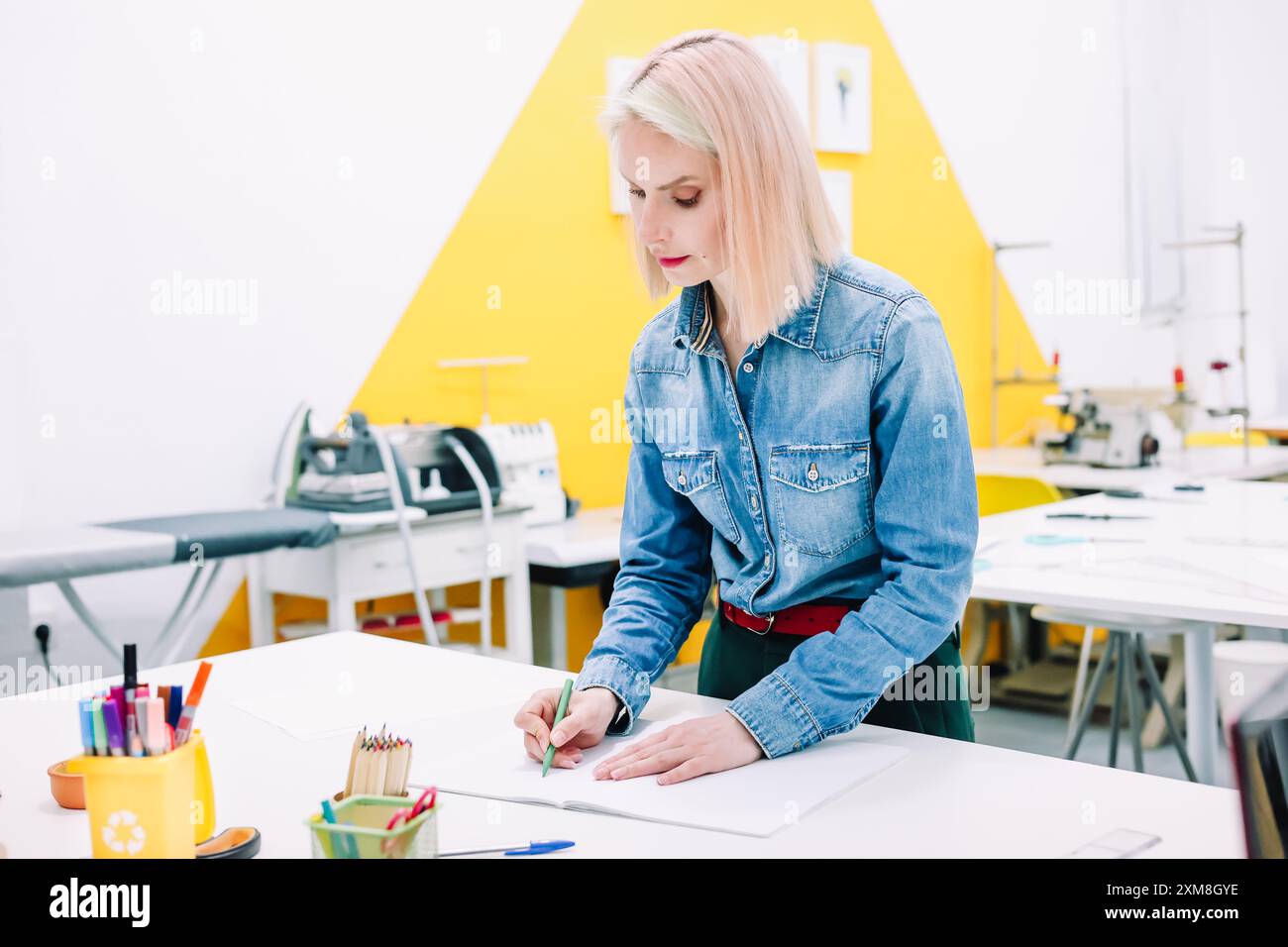 Donna stilista che progetta una collezione di abiti eleganti nel suo studio Foto Stock