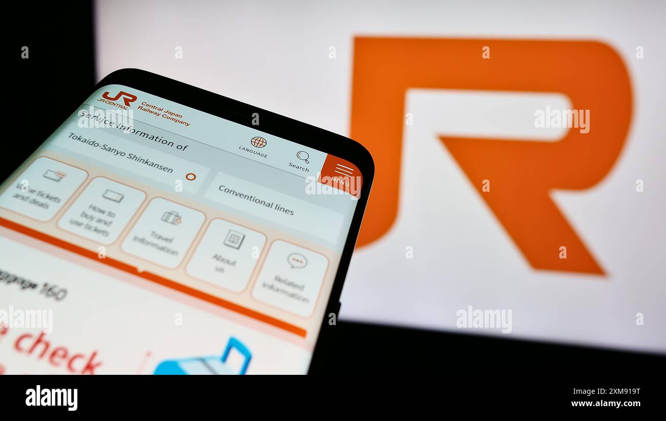 Smartphone con sito web dell'azienda ferroviaria giapponese Central Japan Railway Company davanti al logo aziendale. Mettere a fuoco in alto a sinistra sul display del telefono. Foto Stock