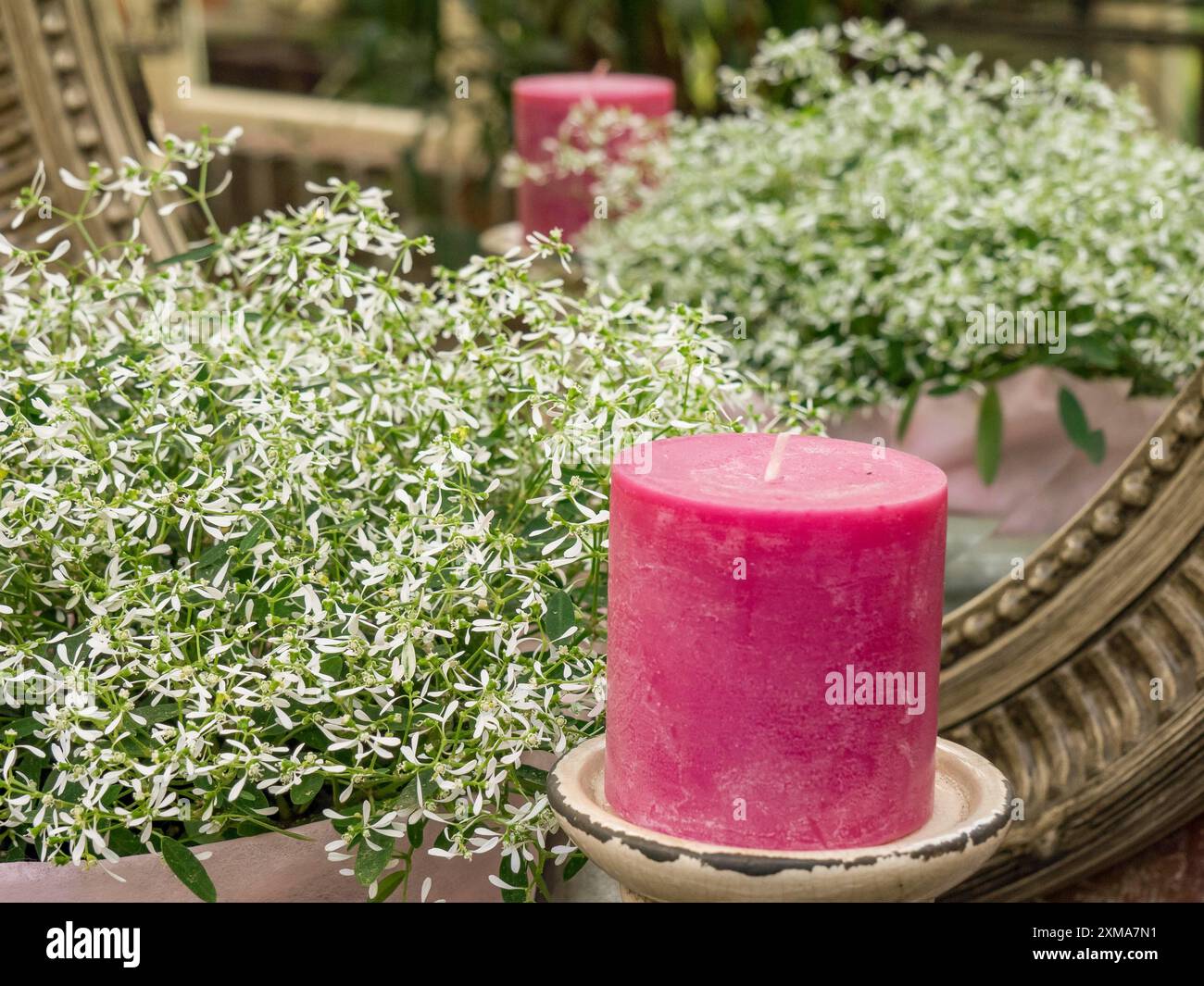 Primo piano di una candela rosa accanto a un bouquet di fiori bianchi davanti a uno specchio, borken, vestfalia, germania Foto Stock