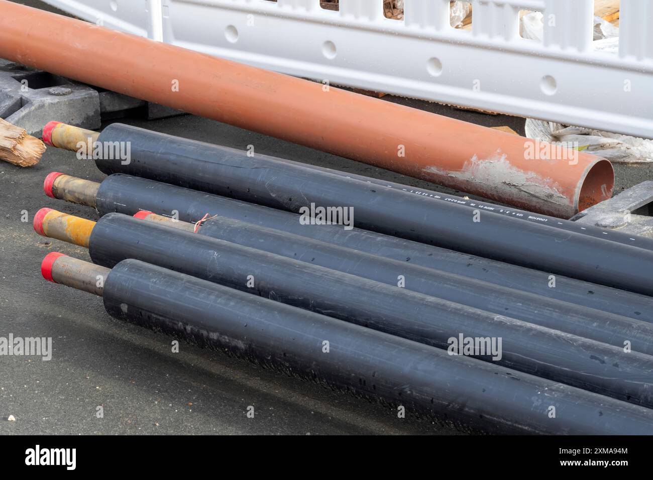 Tubi impilati con contrassegni colorati in cantiere Foto Stock