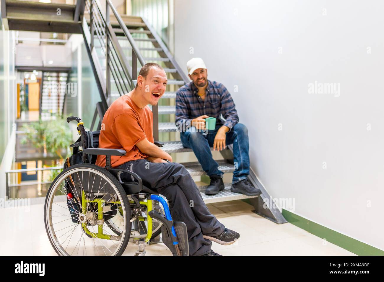 Compagni di lavoro felici con disabilità che si divertono in una pausa di lavoro Foto Stock