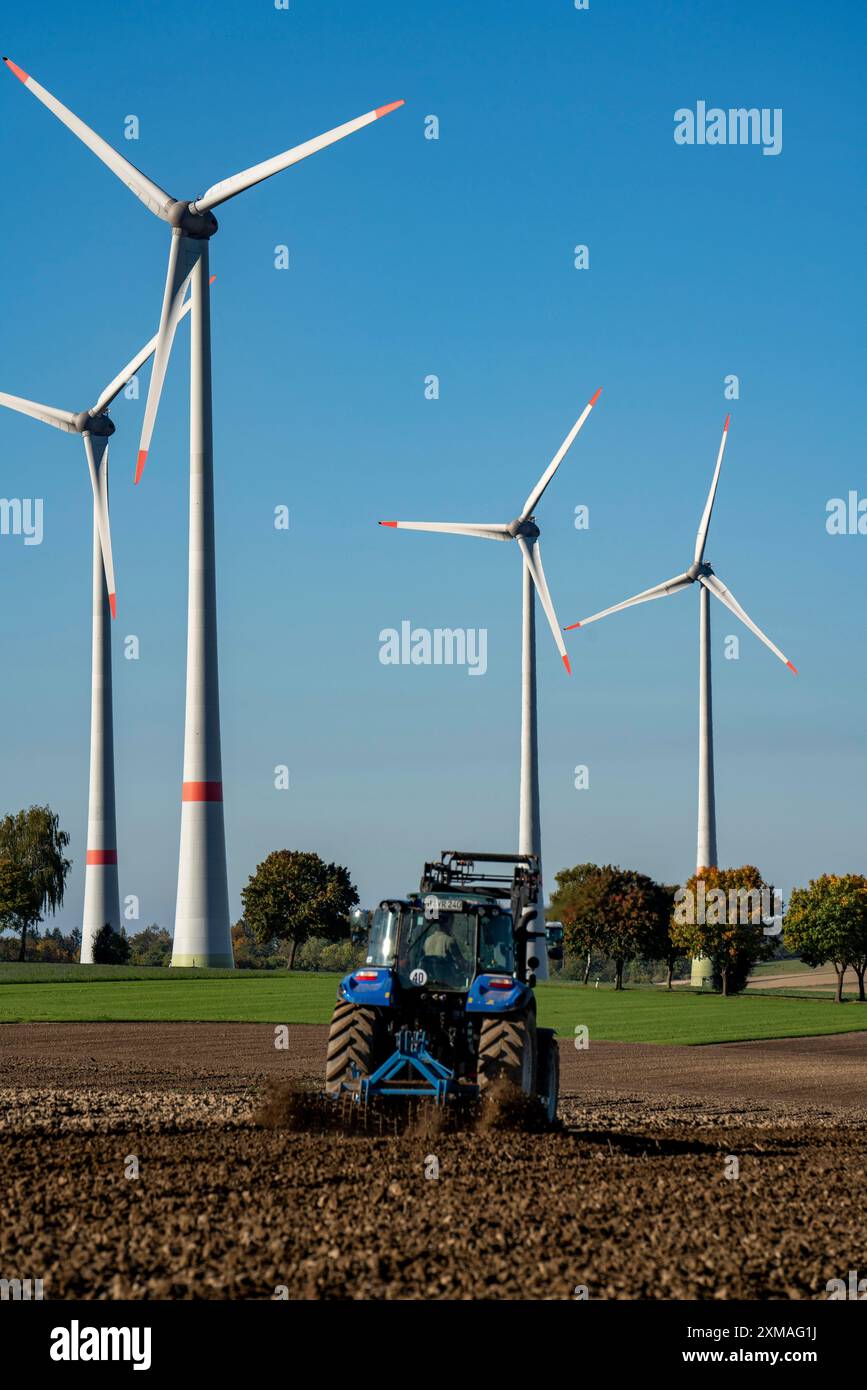 Agricoltore che lavora nei campi, con un trattore, un parco eolico sopra il villaggio di Lichtenau, autoproclamata città energetica, distretto di Paderborn, OWL, A North Foto Stock