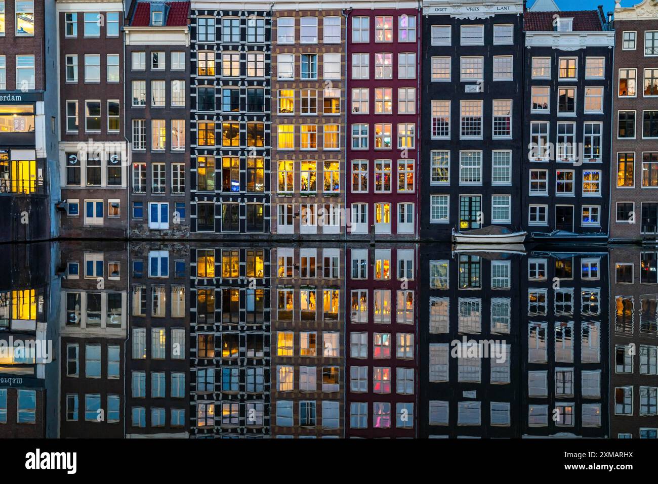 Case sui canali sul Damrak, nel centro della città vecchia di Amsterdam, porto, punto di partenza di molte escursioni sui canali, sera, Paesi Bassi Foto Stock