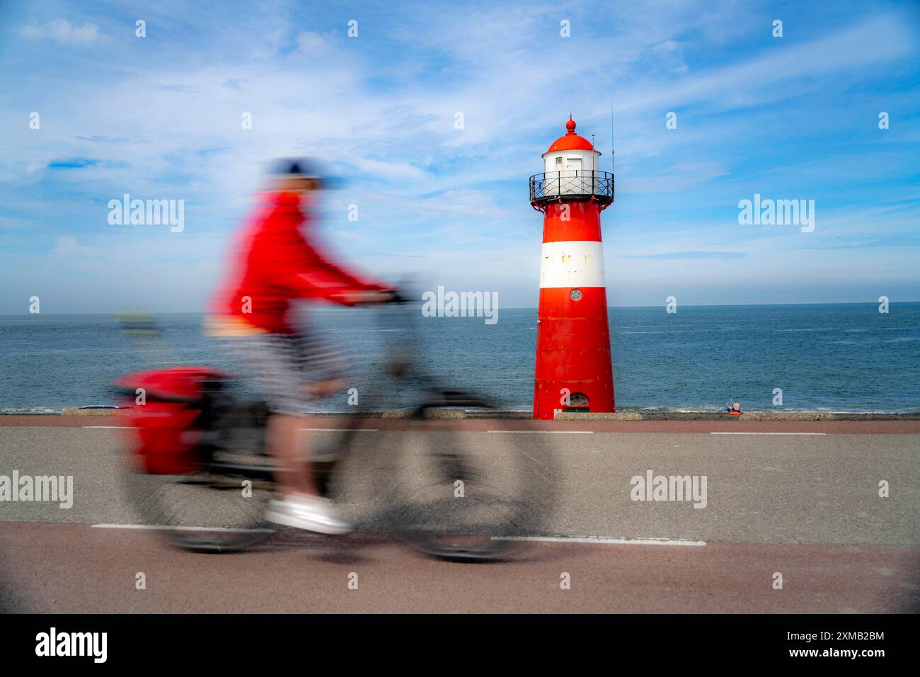 Diga del Mare del Nord vicino a Westkapelle, faro di Westkapelle Laag, ciclisti sulla pista ciclabile Zeeuwse Wind Route, provincia della Zelanda, Walcheren Foto Stock