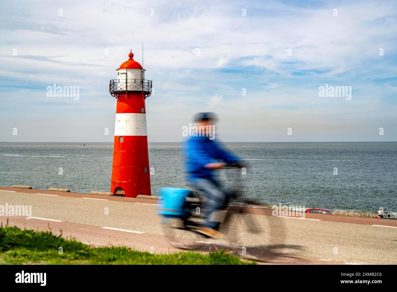 Diga del Mare del Nord vicino a Westkapelle, faro di Westkapelle Laag, ciclisti sulla pista ciclabile Zeeuwse Wind Route, provincia della Zelanda, Walcheren Foto Stock