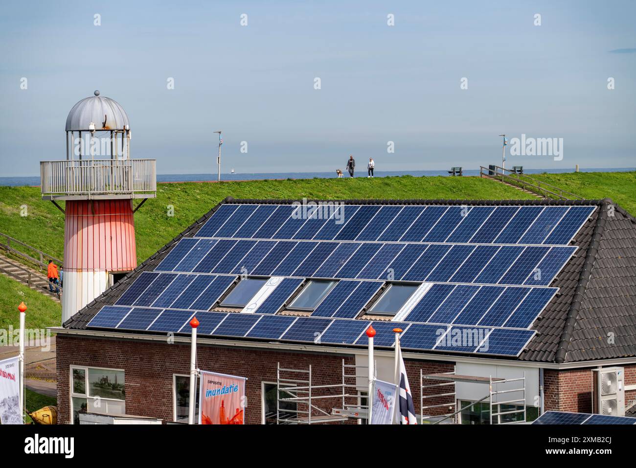 Moduli solari sui tetti, sul tetto di un edificio sulla diga, costa del Mare del Nord, in Zelanda, Westkapelle, Paesi Bassi Foto Stock