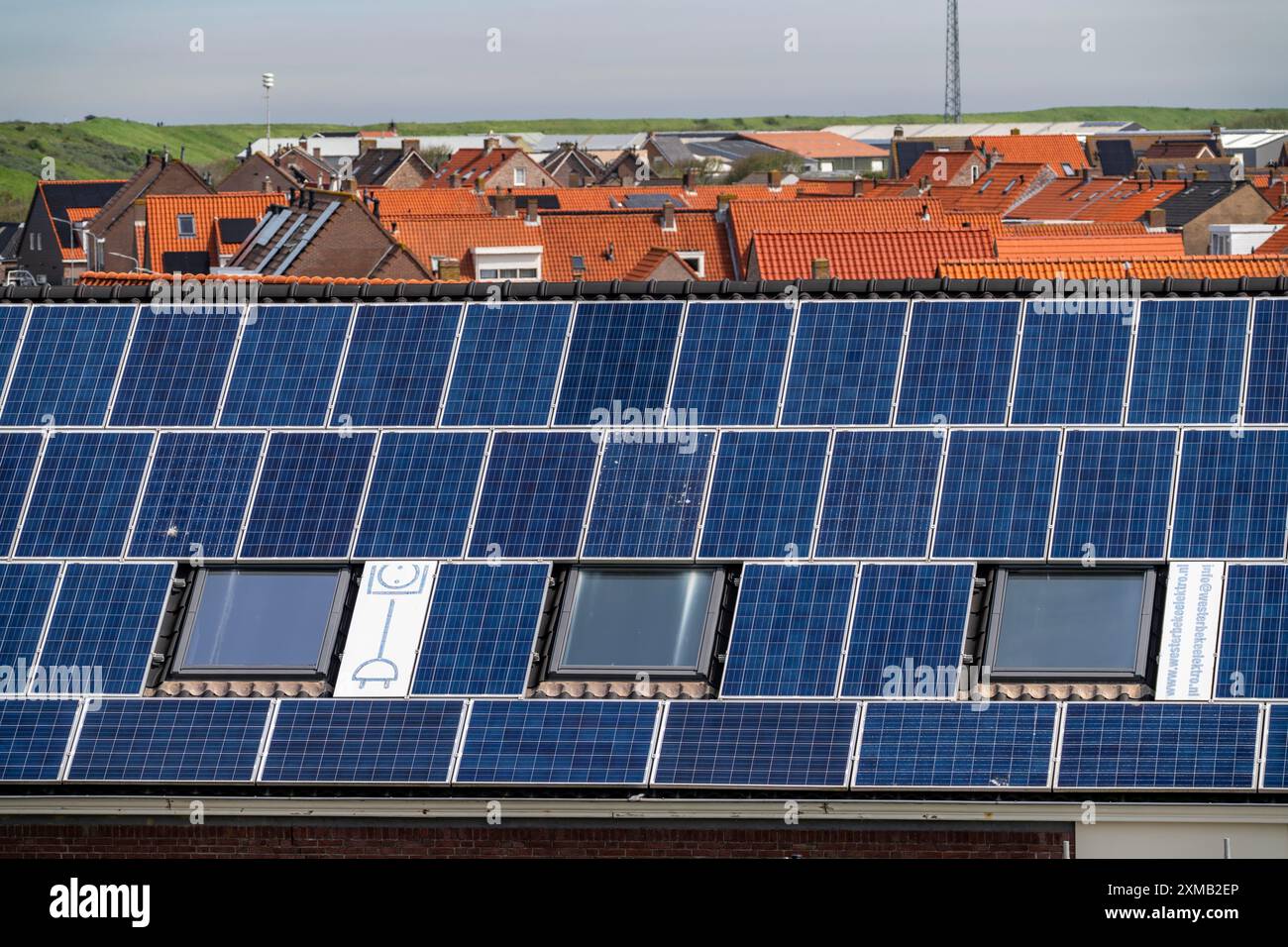 Moduli solari sui tetti, sul tetto di un edificio sulla diga, costa del Mare del Nord, in Zelanda, Westkapelle, Paesi Bassi Foto Stock
