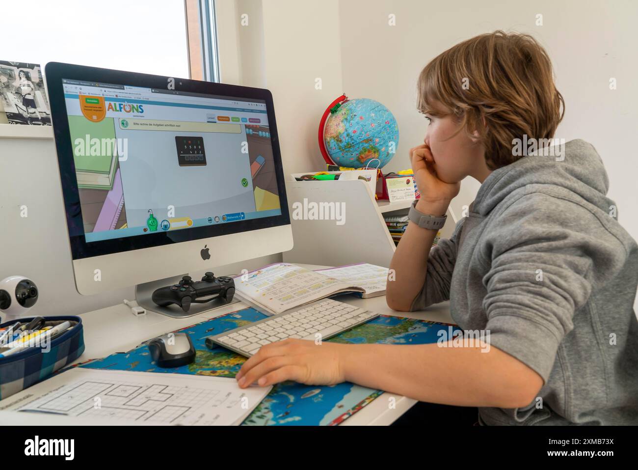 Giovani, alunni delle scuole primarie, apprendimento a domicilio, lavoro scolastico, apprendimento a distanza, classe virtuale, a casa al computer, effetti della corona Foto Stock