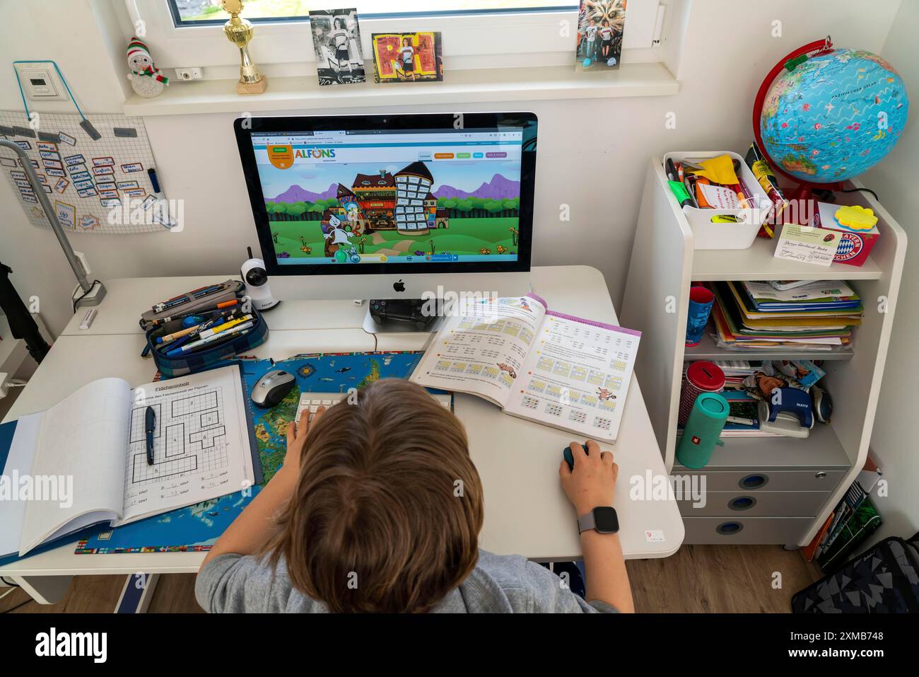 Giovani, alunni delle scuole primarie, apprendimento a domicilio, lavoro scolastico, apprendimento a distanza, classe virtuale, a casa al computer, effetti della corona Foto Stock
