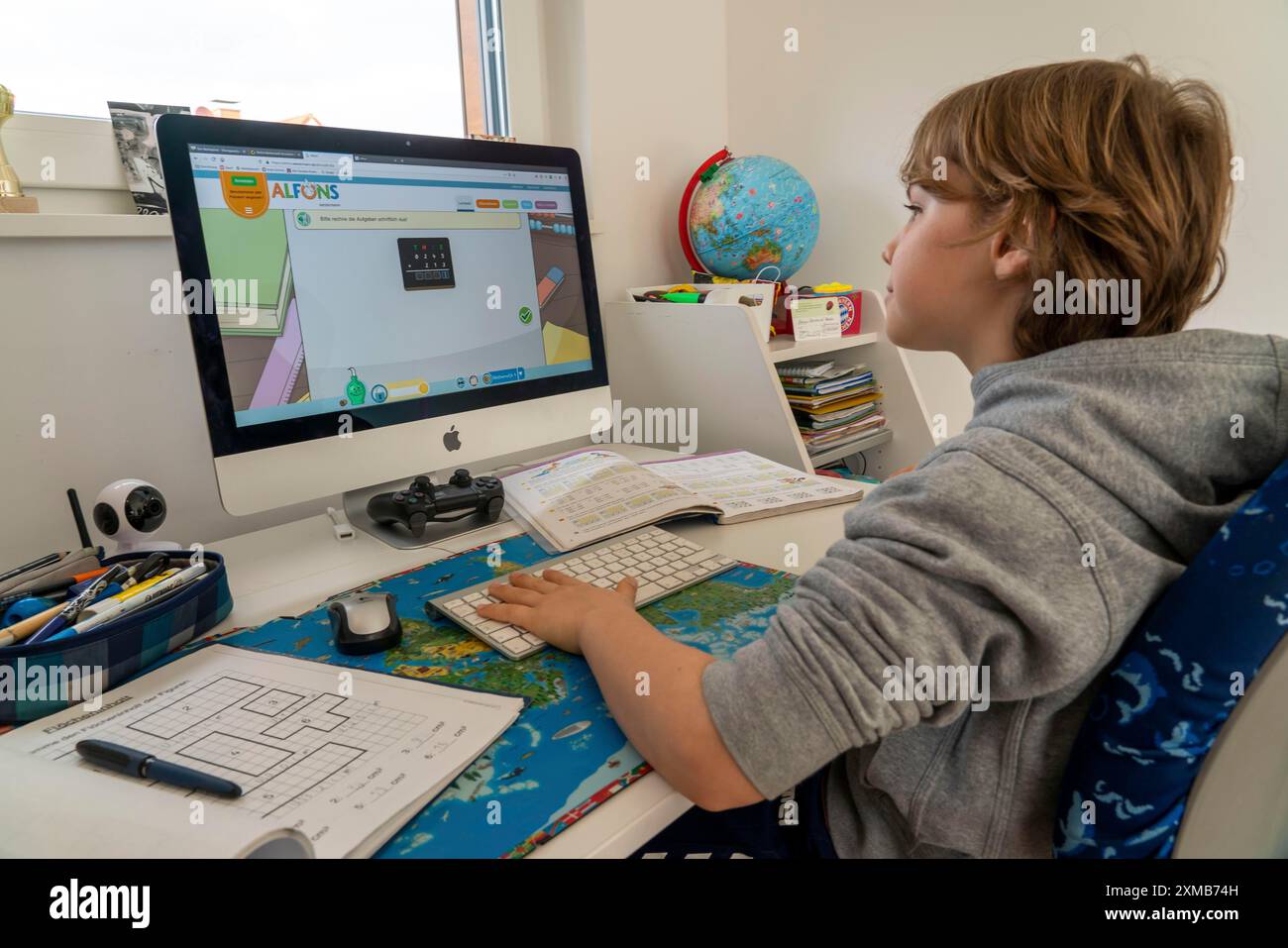 Giovani, alunni delle scuole primarie, apprendimento a domicilio, lavoro scolastico, apprendimento a distanza, classe virtuale, a casa al computer, effetti della corona Foto Stock