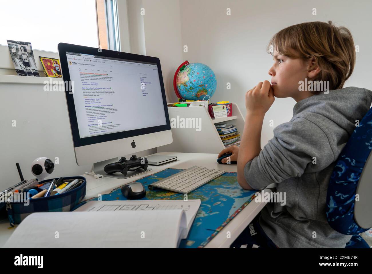 Giovani, alunni delle scuole primarie, apprendimento a domicilio, lavoro scolastico, apprendimento a distanza, classe virtuale, a casa al computer, effetti della corona Foto Stock