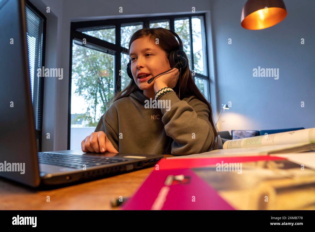 Homeschooling, ragazza, 11 anni, impara a casa, a casa, lezioni a casa, apprendimento a distanza, chat con insegnanti e compagni di classe tramite laptop Foto Stock
