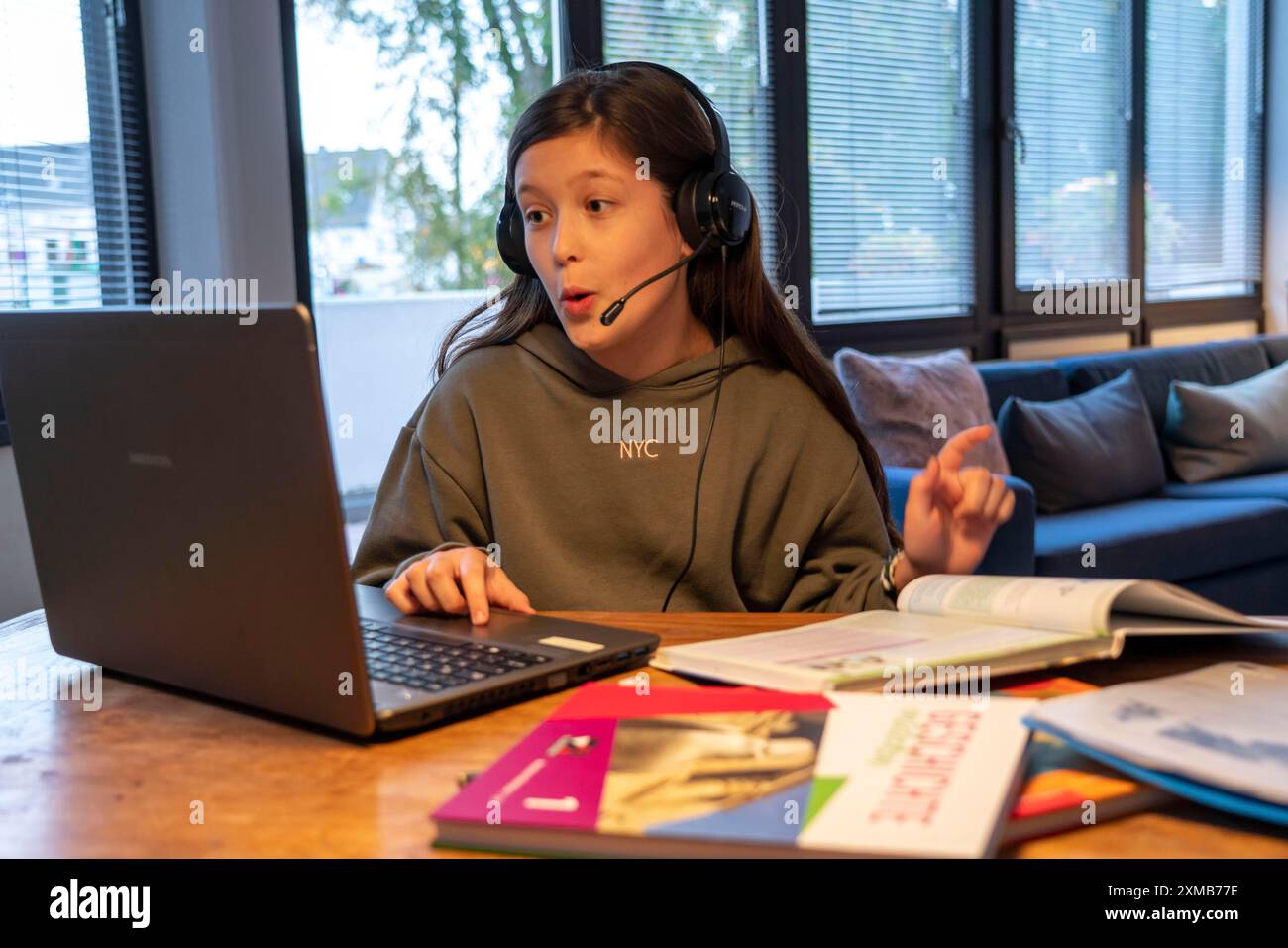 Homeschooling, ragazza, 11 anni, impara a casa, a casa, lezioni a casa, apprendimento a distanza, chat con insegnanti e compagni di classe tramite laptop Foto Stock