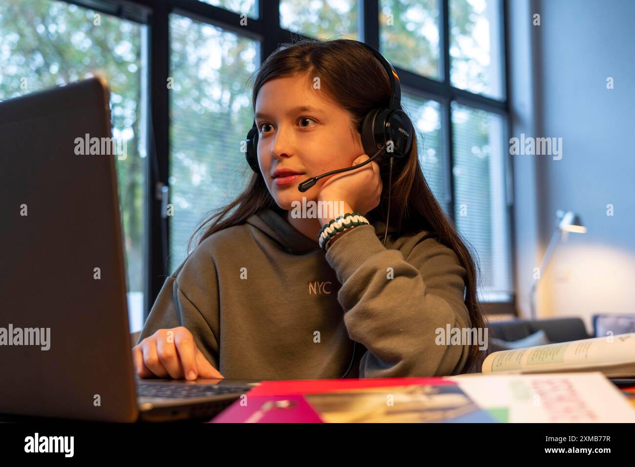 Homeschooling, ragazza, 11 anni, impara a casa, a casa, lezioni a casa, apprendimento a distanza, chat con insegnanti e compagni di classe tramite laptop Foto Stock