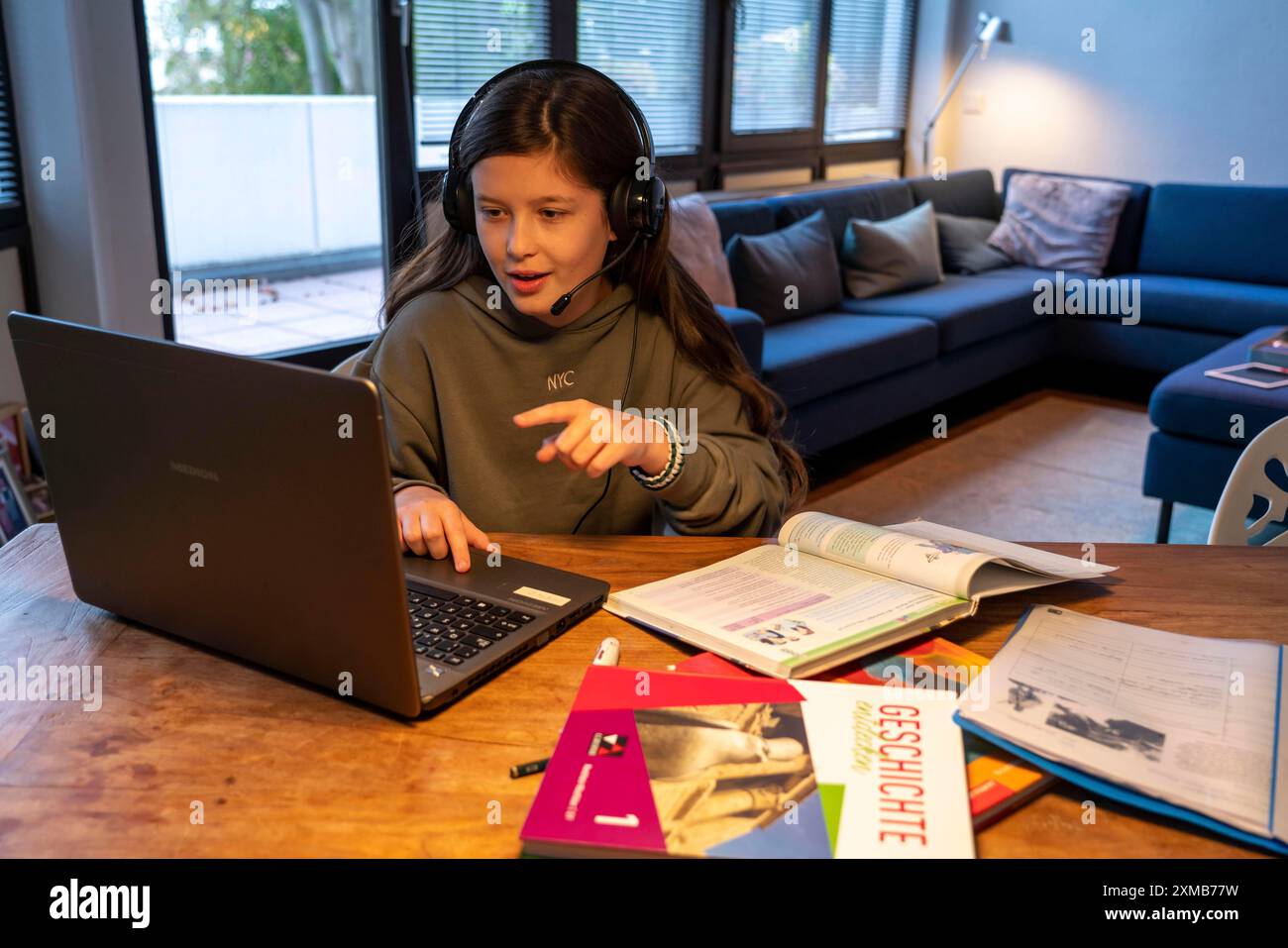 Homeschooling, ragazza, 11 anni, impara a casa, a casa, lezioni a casa, apprendimento a distanza, chat con insegnanti e compagni di classe tramite laptop Foto Stock
