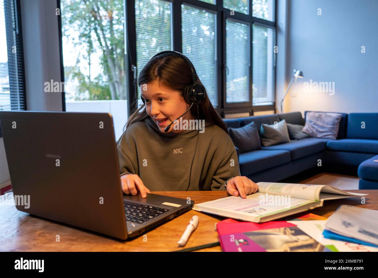 Homeschooling, ragazza, 11 anni, impara a casa, a casa, lezioni a casa, apprendimento a distanza, chat con insegnanti e compagni di classe tramite laptop Foto Stock