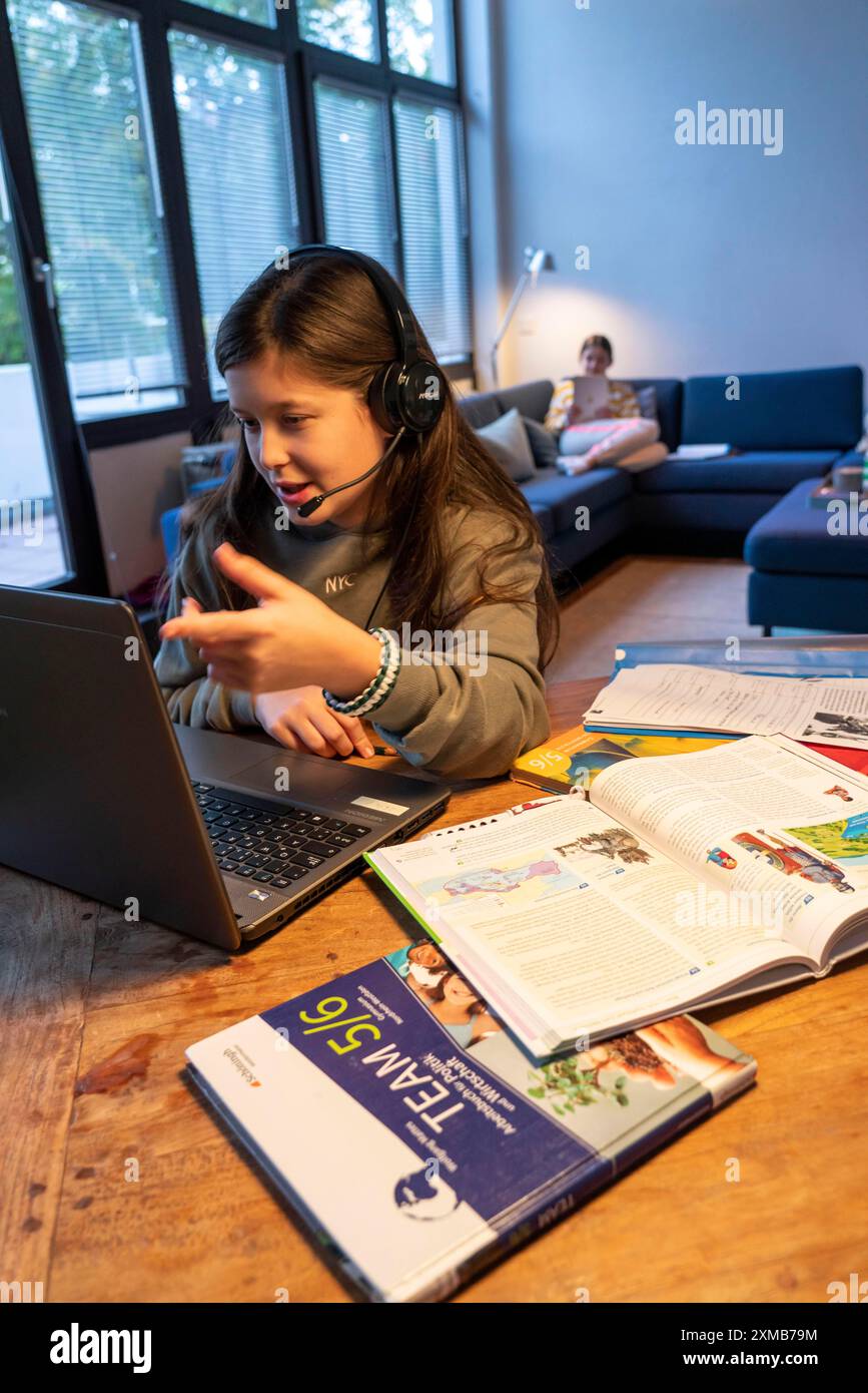 Homeschooling, 2 ragazze, sorelle, 11 anni, imparare a casa, apprendimento a casa, lezioni a casa, apprendimento a distanza, chat con insegnanti e compagni di classe Foto Stock