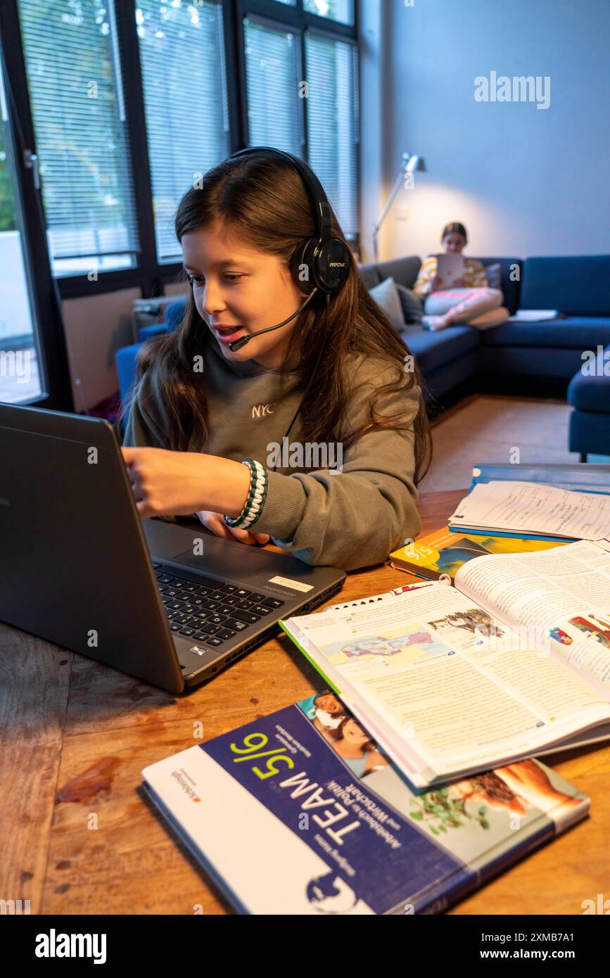 Homeschooling, 2 ragazze, sorelle, 11 anni, imparare a casa, apprendimento a casa, lezioni a casa, apprendimento a distanza, chat con insegnanti e compagni di classe Foto Stock