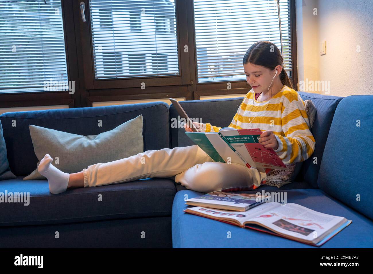 Homeschooling, ragazza, 11 anni, impara a casa, a casa, lezioni a casa, apprendimento a distanza, chat con insegnanti e compagni di classe tramite tablet Foto Stock