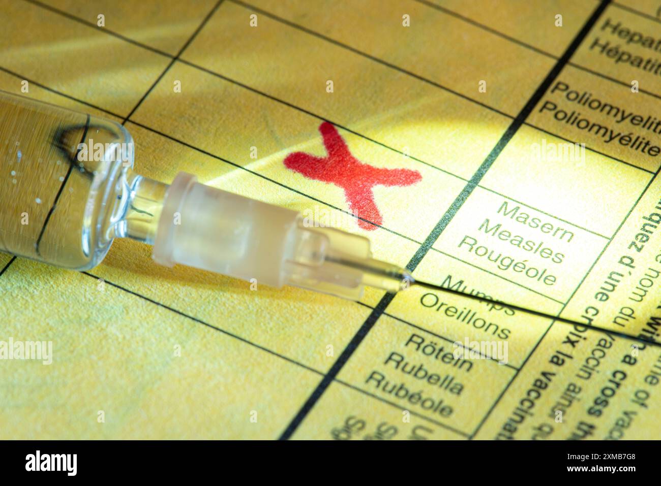 Foto simbolica vaccinazione contro il morbillo, certificato di vaccinazione, siringa con vaccino contro il morbillo Foto Stock