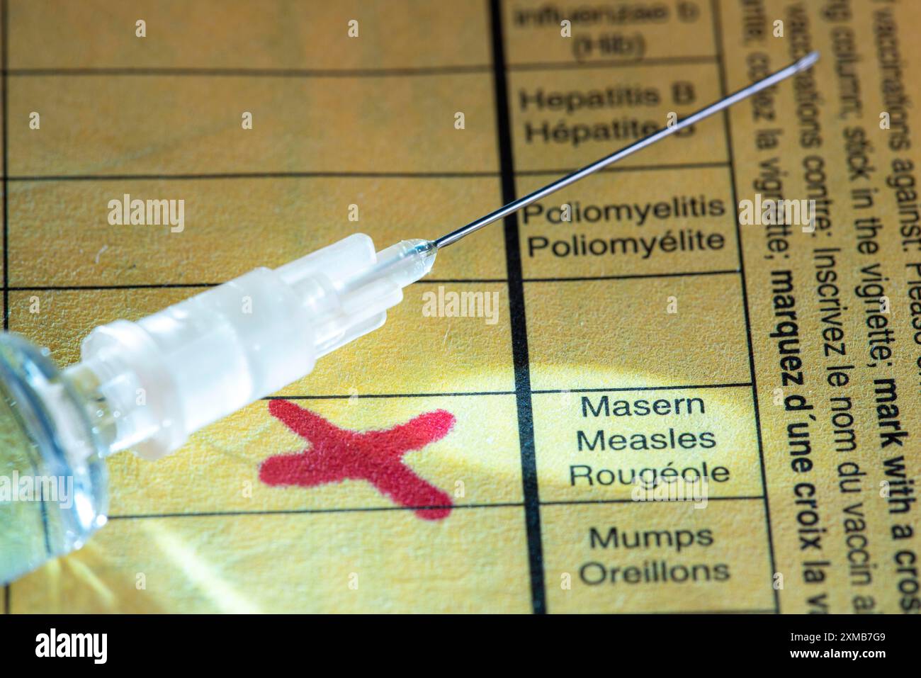 Foto simbolica vaccinazione contro il morbillo, certificato di vaccinazione, siringa con vaccino contro il morbillo Foto Stock