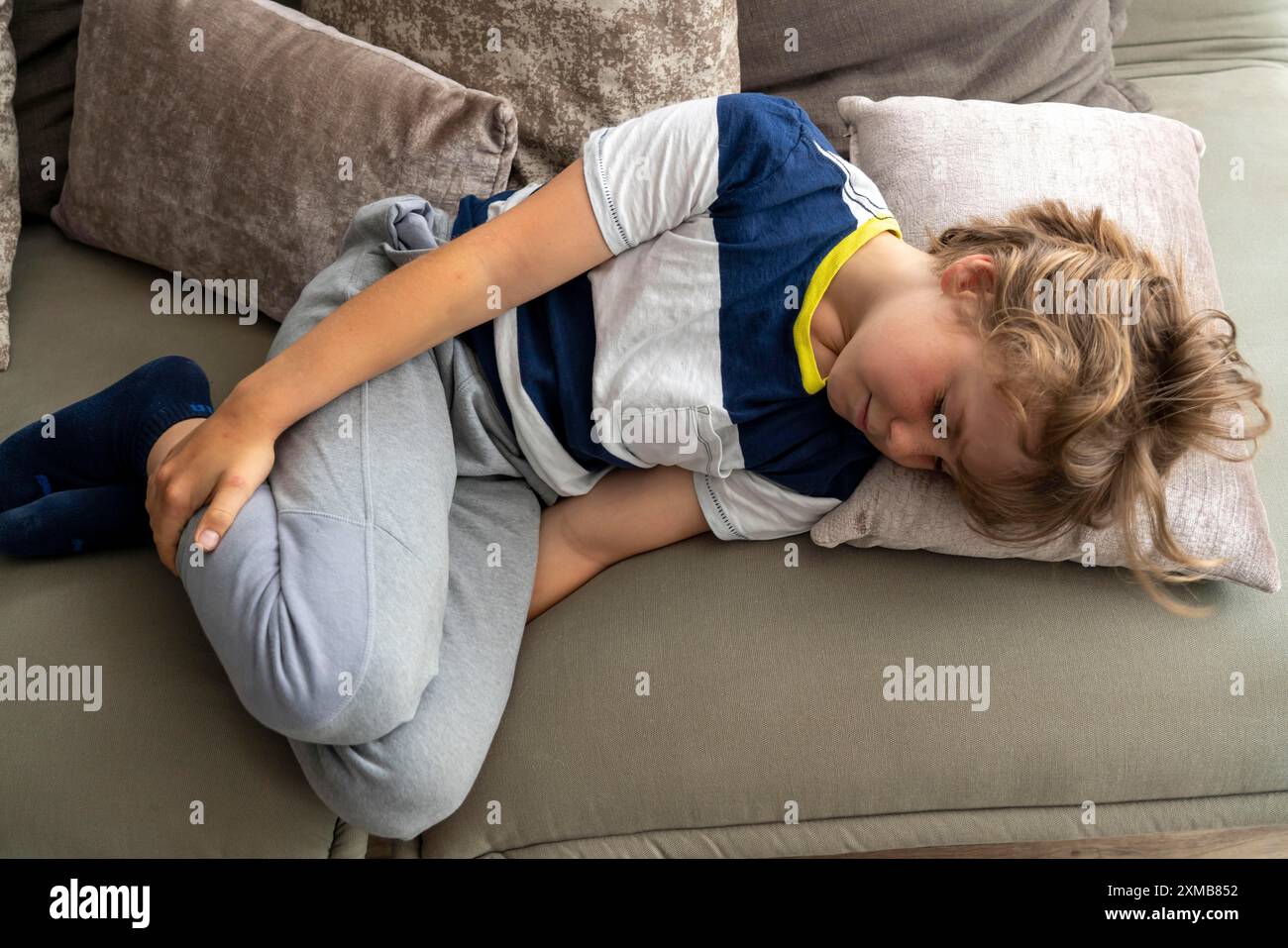 I dolori crescenti nei bambini, ragazzo di 10 anni, hanno dolore alla gamba, immagine simbolica Foto Stock