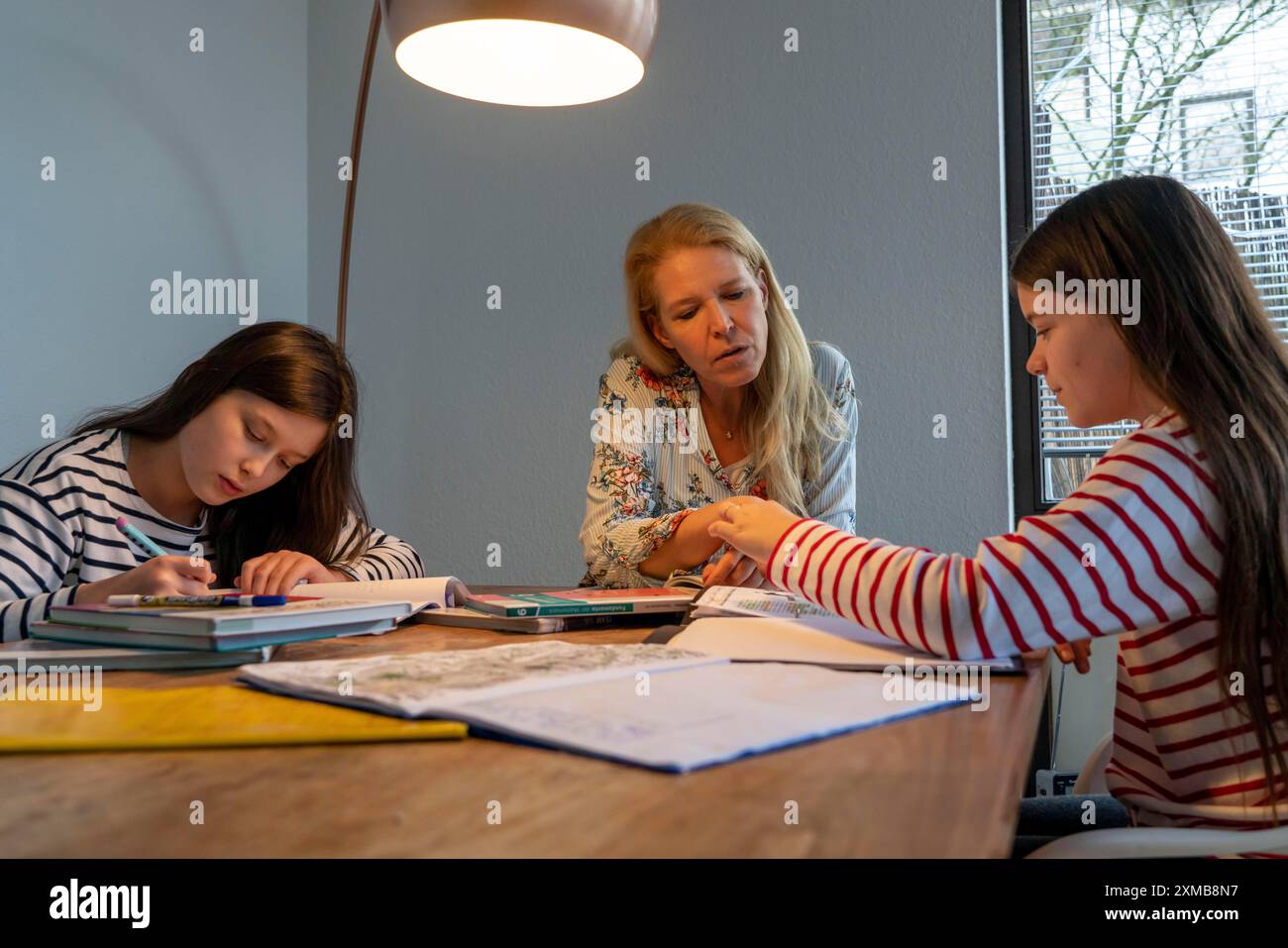 Homeschooling, durante il blocco nel gennaio 2021, la madre aiuta le sue due figlie, a casa, a imparare, a chiudere le scuole, a distanza, effetti di Foto Stock