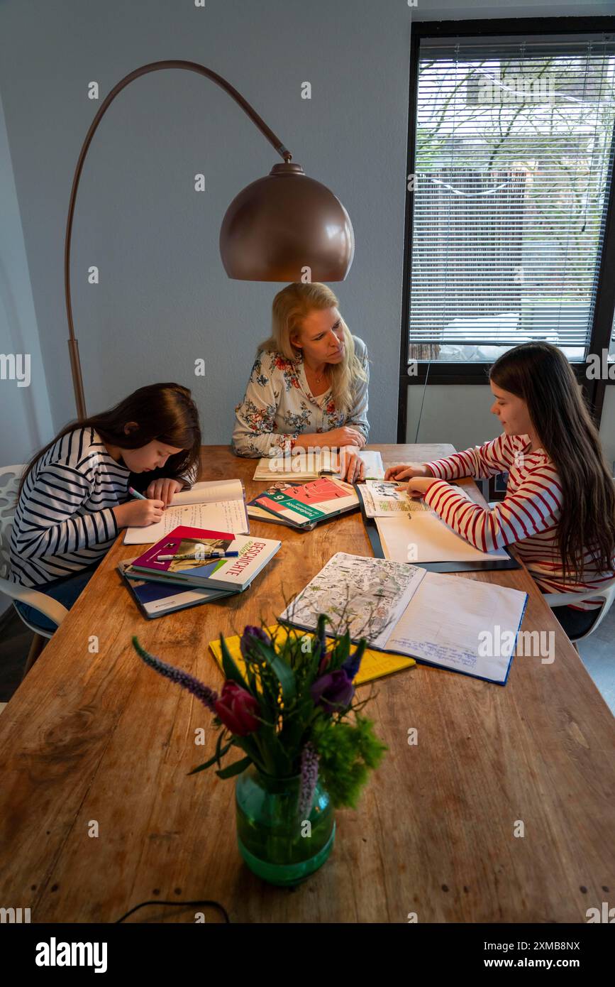 Homeschooling, durante il blocco nel gennaio 2021, la madre aiuta le sue due figlie, a casa, a imparare, a chiudere le scuole, a distanza, effetti di Foto Stock