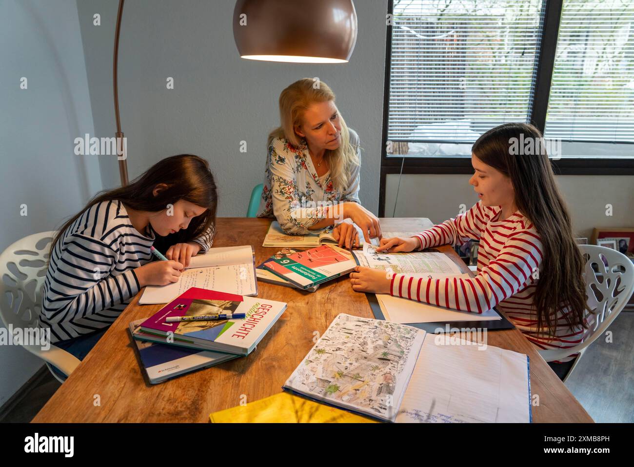 Homeschooling, durante il blocco nel gennaio 2021, la madre aiuta le sue due figlie, a casa, a imparare, a chiudere le scuole, a distanza, effetti di Foto Stock