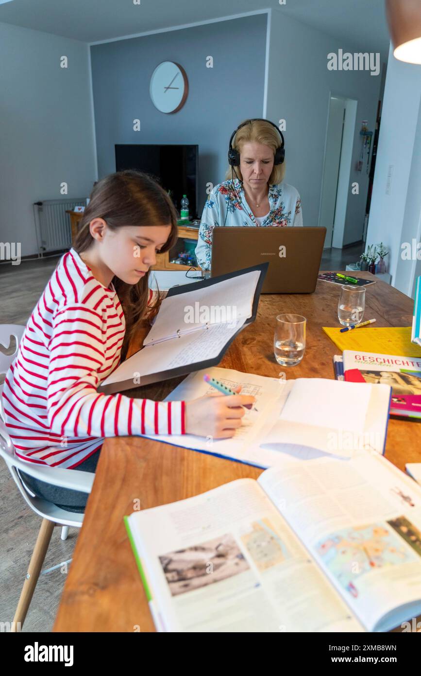 Homeschooling, durante il blocco nel gennaio 2021, i bambini imparano a casa per la scuola, la loro mamma è in ufficio e lavora con il laptop Foto Stock